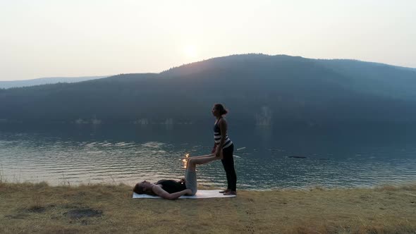 Women practicing acroyoga near lakeside 4k