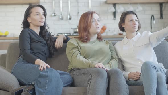 Relaxed Caucasian Women Sitting on Couch Watching TV and Talking