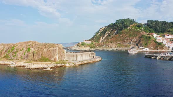 Cudillero Lighthouse on Rocky Cliff, Flyover through Port Breakwater, Asturias. Spain