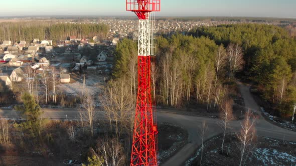 Mobile Phone Tower in the Forest Taiga Near the Electrified Railway in Sunny Winter Weather