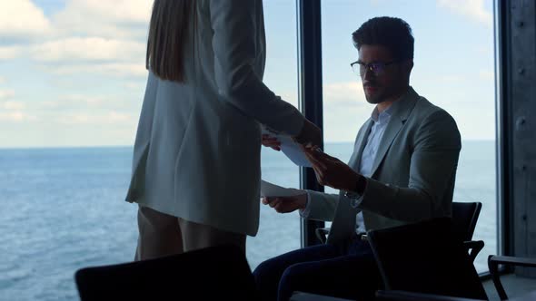 Businessman Checking Contract Papers at Panorama Window