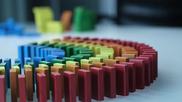 Line up of Dominoes in Rainbow Falling Colors with LGBT Colors of a Hand