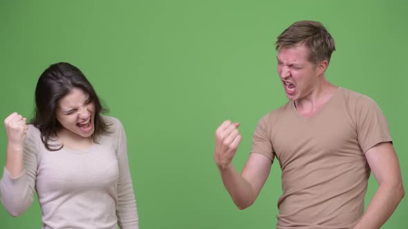 Young Couple Giving High-five Together Against Green Background