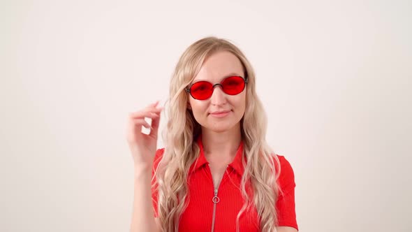 Portrait of a Girl in Red Glasses and a Red Tshirt on a White Background