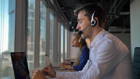 Handsome Male in Headset Calling in Business Office Call Center