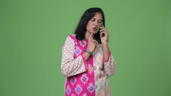 Mature Beautiful Indian Woman Thinking While Talking on the Phone