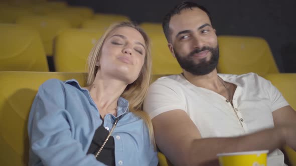 Loving Multiethnic Couple Watching Film in Cinema. Portrait of Happy Middle Eastern Man