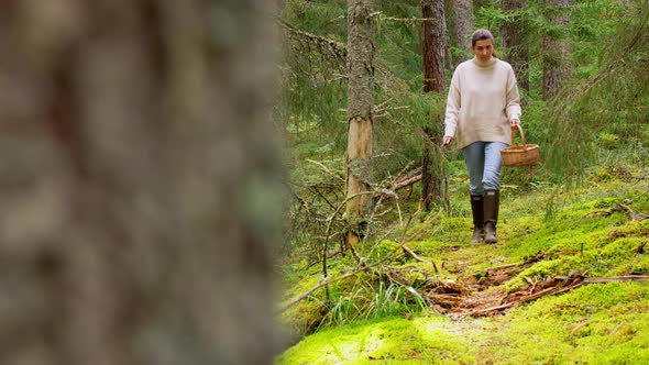 Woman with Mushrooms in Basket Walking in Forest