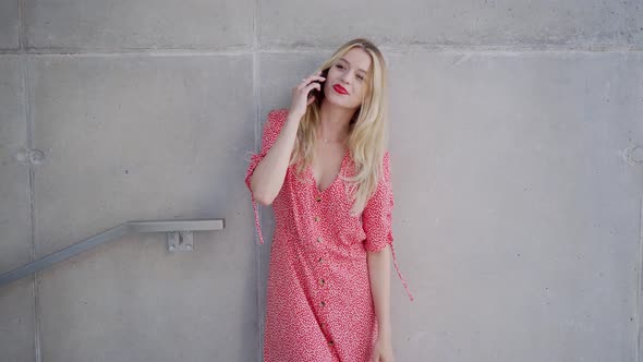 Stylish Female Speaking on Smartphone Near Concrete Wall