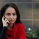 Young Business Lady Talking on a Cell Phone Sitting at a Table in a Cafe on the Street - VideoHive Item for Sale