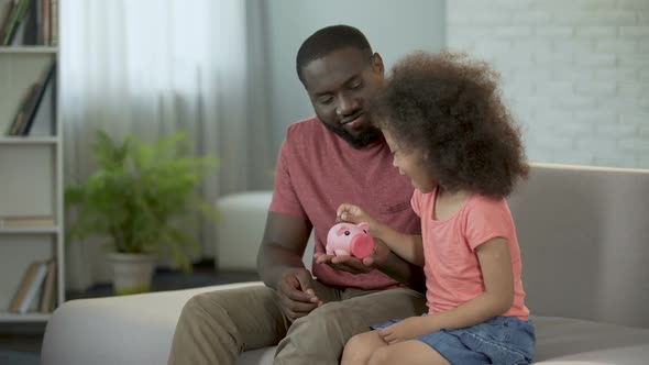 Caring Father Teaching Child to Save Money, Putting Coins Into Piggy Bank