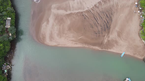 Aerial view of Baron beach in Yogyakarta, Indonesia with lighthouse and traditional boats