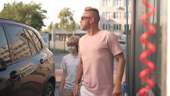 Cute Caucasian Boy and Confident Man Talking Walking at Clean Vehicle at Car Wash Service