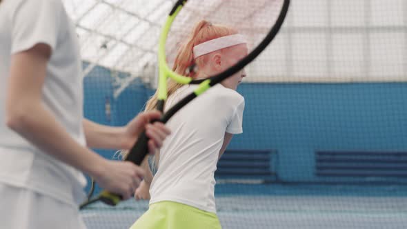 Little Girls Practicing Tennis On Court