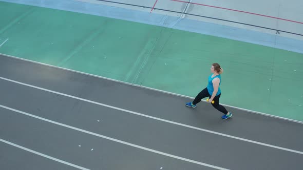 Aerial View of Woman Doing Lunges on Stadium Track