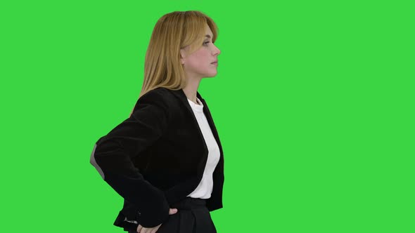 Walking Businesswoman with Hands in Pockets on a Green Screen, Chroma Key.