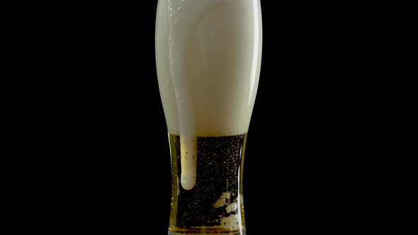 Light Beer In A Glass With Bubbles,Draft Beer In A Glass On A Black Background