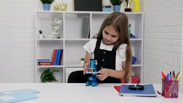 Busy Schoolgirl Using Microscope on Biology Lesson Education