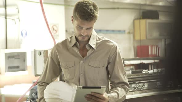 Man looking at digital tablet while working in factory