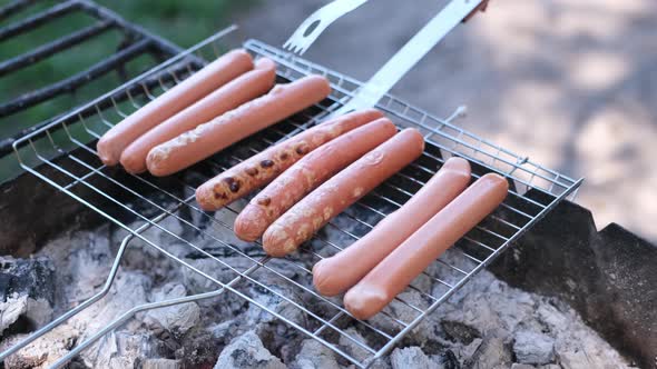 Closeup View of Tasty Sausages Grilling on Charcoal Grill Grate