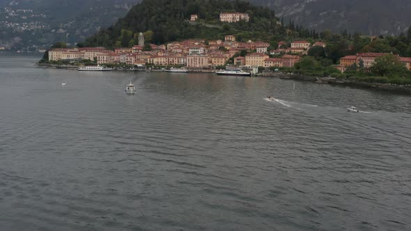 Aerial of boats on a busy lake near a beautiful Italian coastal city