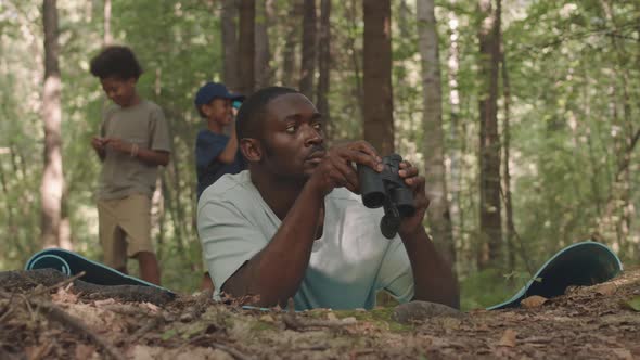 Black Man Looking Through Binoculars in Forest