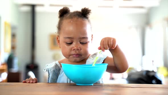 Young South African girl eating her lunch with a blue bowl