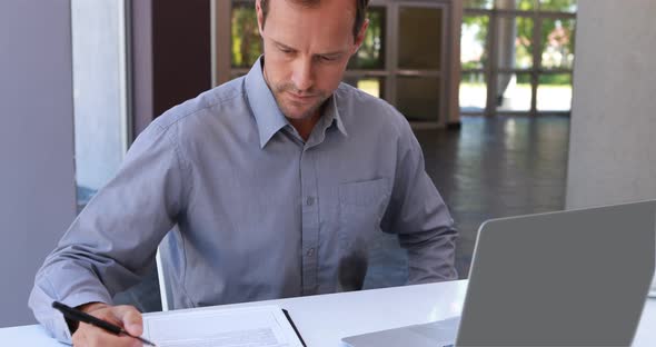 Male executive working on laptop at desk 4k