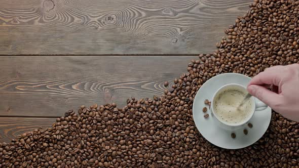 Caucasian Hand Stirring Black Frothy Coffee and with a Spoon