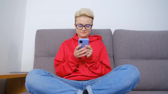 Young tomboy female using modern mobile phone for communication online in 4k stock video