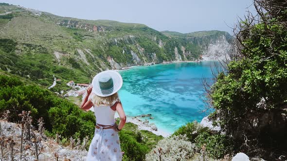 Happy Female Tourist with Straw Hat Admire Sea Bay Panorama During Summer Vacation