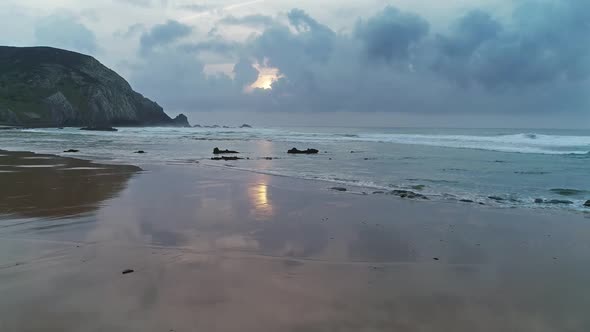 Flying Over Sandy Beach with Reflection Sunset