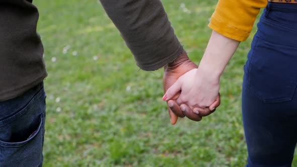 Black Man and White Woman Hands Holding in the park.slow motion