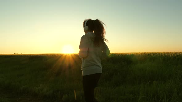 Healthy Beautiful Girl Doing Fitness Jogging on a Wheat Field. Training Run. Free Young Woman Runs