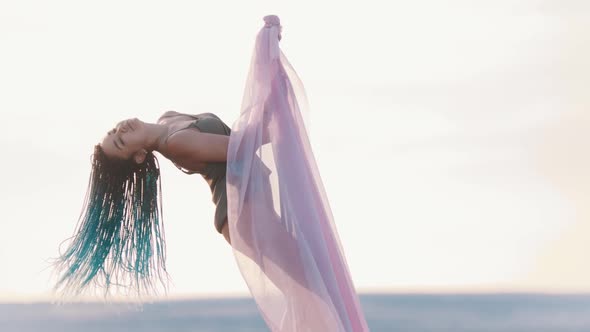 Pole Dance Outdoors - Woman with Blue Braids Spinning on the Pole with Pink Veil