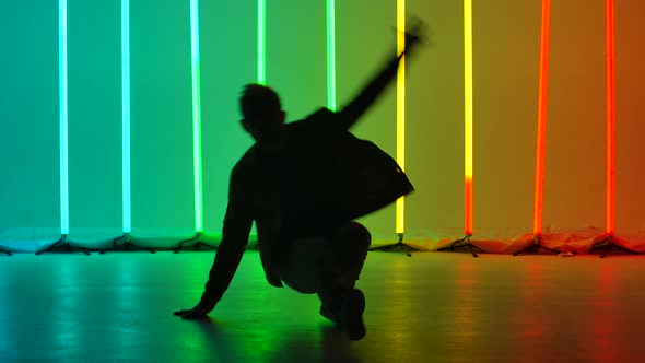 Street Male Dancer in Stylish Clothes Performs Complex Dance Breakdance Elements and Handstands. Man