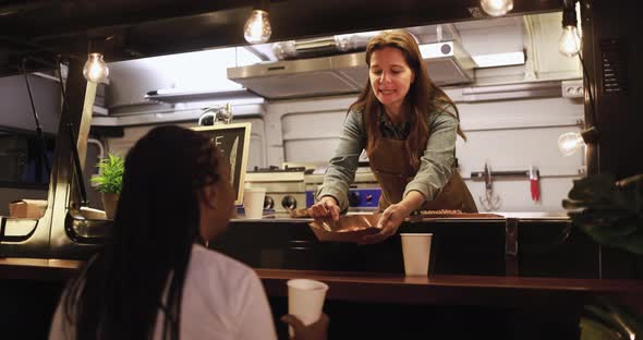 Caucasian woman chef working inside food truck preparing dinner food