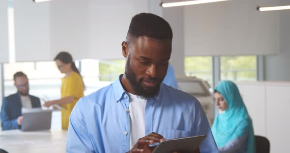 Handsome Afroamerican Businessman Using Tablet While Working in Office