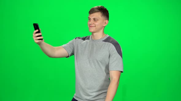 Funny Man Goes and Takes a Selfie with Smartphone on Green Screen at Studio