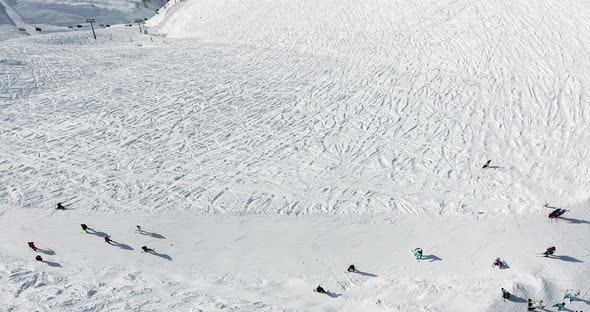 People Glide Down the Ski Slope on Skis and Snowboards