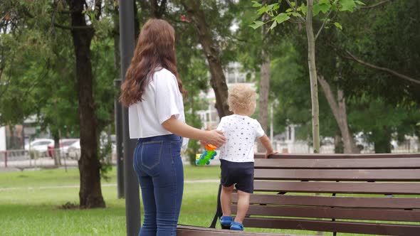 Mother and Little Child Walk in the Park in Summer Toddler Boy Playing on a Path on Sunny Day