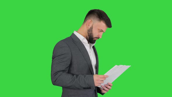 Turk Businessman Standing and Looking at Documents on a Green Screen, Chroma Key.