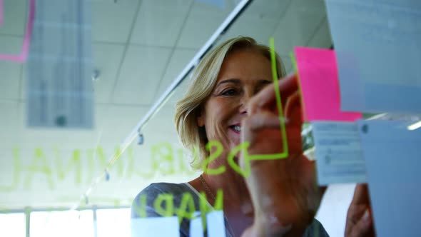 Female executive looking at sticky notes