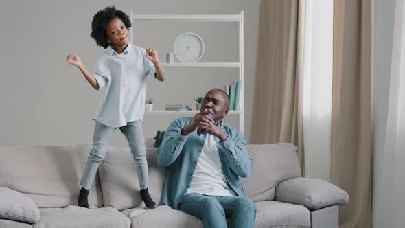 African American Father with Daughter Having Fun Together Mature Man Sitting in Room on Couch
