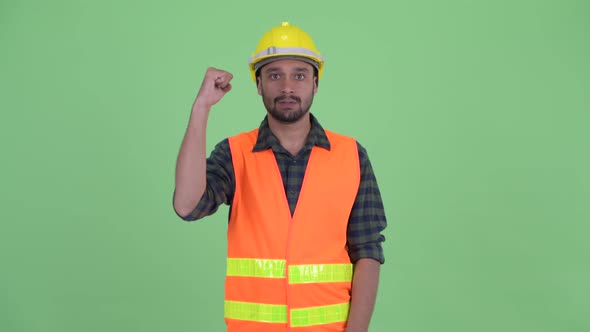 Happy Young Bearded Persian Man Construction Worker with Fist Raised