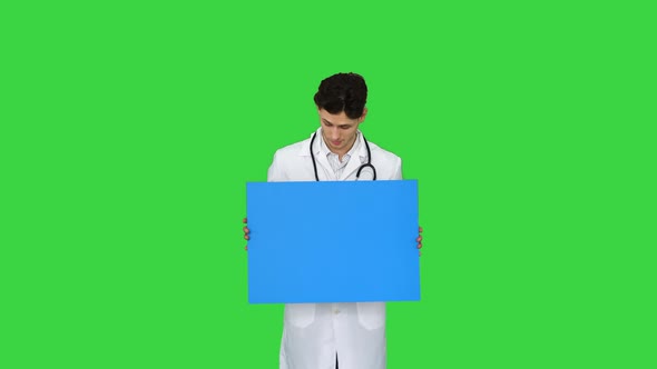 Happy Smiling Male Doctor Showing Blank Signboard and Dancing on a Green Screen, Chroma Key.