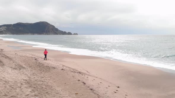 Jogging young female during outdoor cardio training at seashore