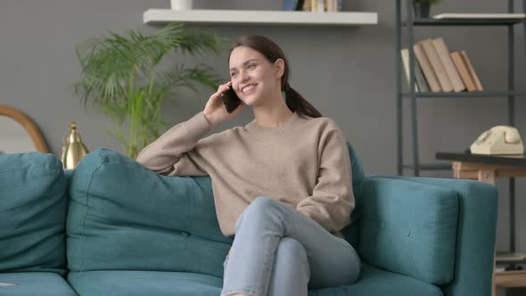 Woman Talking on Smartphone on Sofa