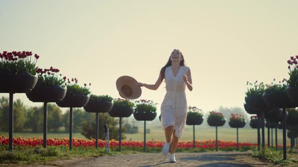 Young Woman Running in Park with Flowers