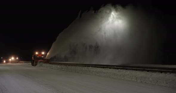 The Grader Removes Snow On The Road Outside The City At Night 